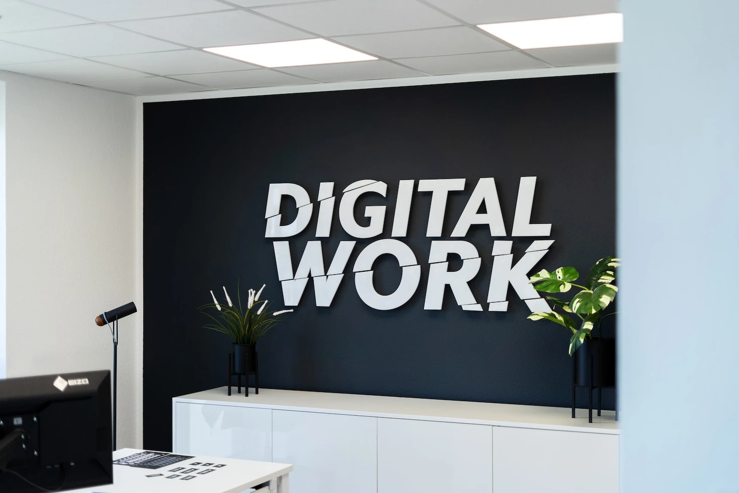Empfang von marketingkollektiv mit dem Schriftzug „Digital Work“ an dunkler Wand